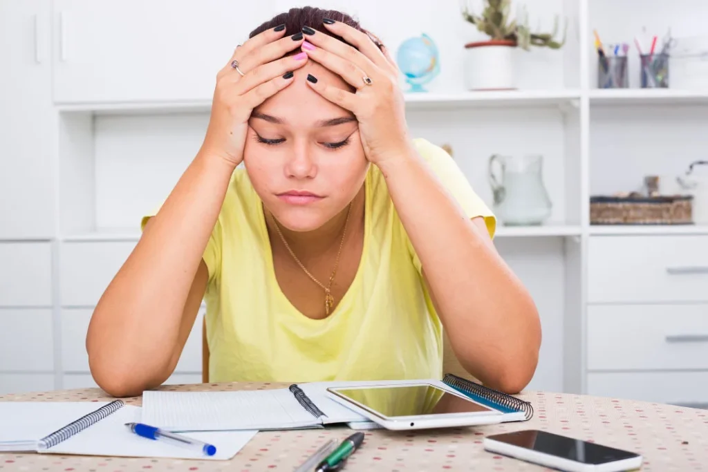 A girl being sad while studying.